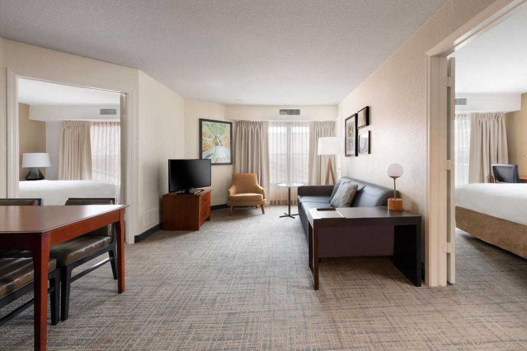 Cette chambre comprend un lit, un canapé et un bureau. dans l'établissement Residence Inn by Marriott Rogers, à Rogers