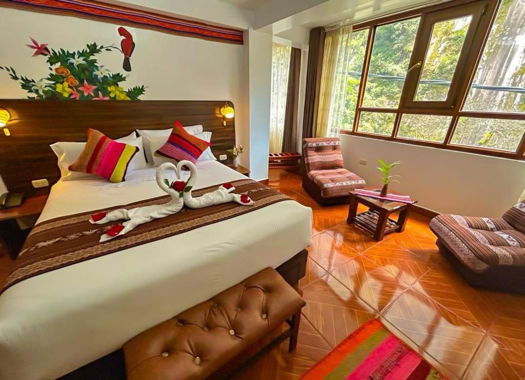 - une chambre avec un grand lit et des serviettes dans l'établissement Machupicchu Adventure Hotel, à Machu Picchu