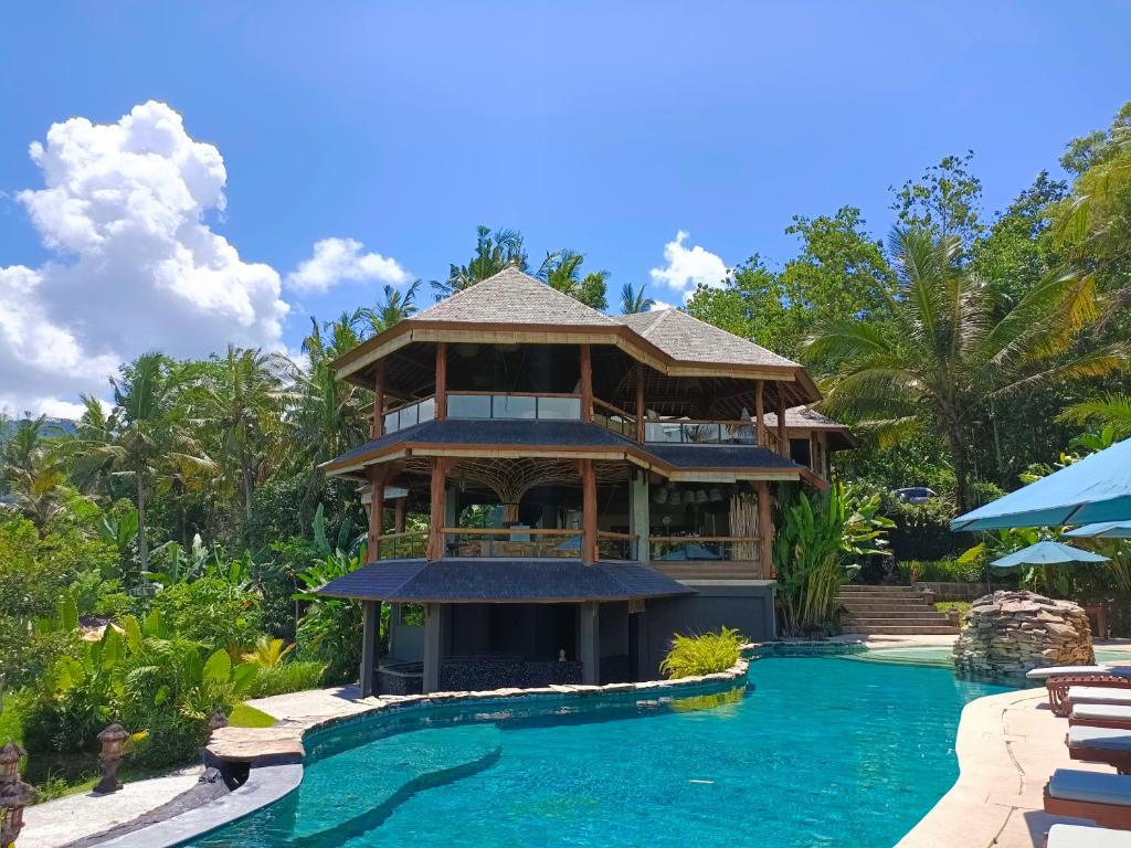 una casa con piscina frente a un complejo en Sunrise Paradise Bali, en Karangasem