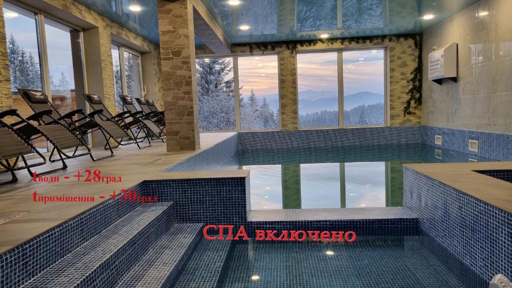 basen z krzesłami w budynku z widokiem na góry w obiekcie SPA hotel Villa Sofia w mieście Jabłonica