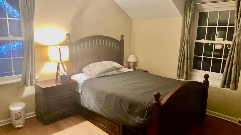 ein Schlafzimmer mit einem Bett, einer Lampe und zwei Fenstern in der Unterkunft B1 A private room in Naperville downtown with desk and Wi-Fi near everything in Naperville