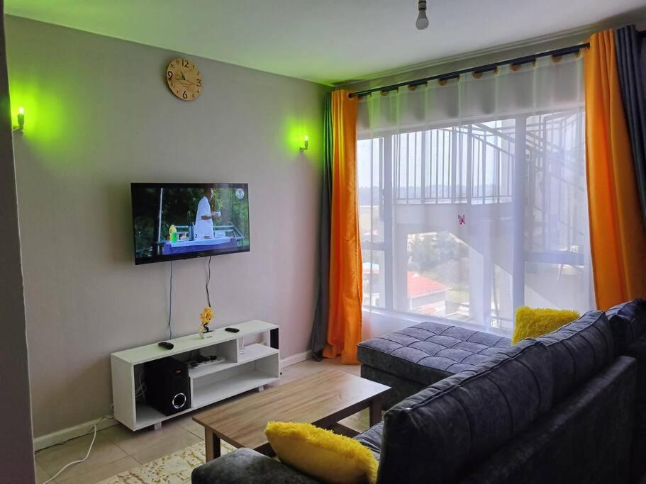 salon z kanapą i telewizorem w obiekcie Legatus Cozy Homes w mieście Ongata Rongai 