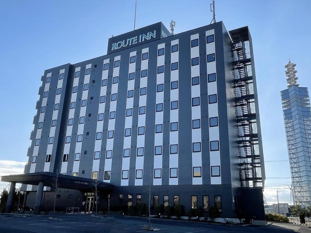 a hotel building with a sign on top of it at Hotel Route-Inn Akita Tsuchizaki in Akita