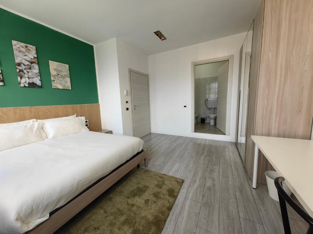 a bedroom with a white bed and a green wall at MILANFORESTER in Milan