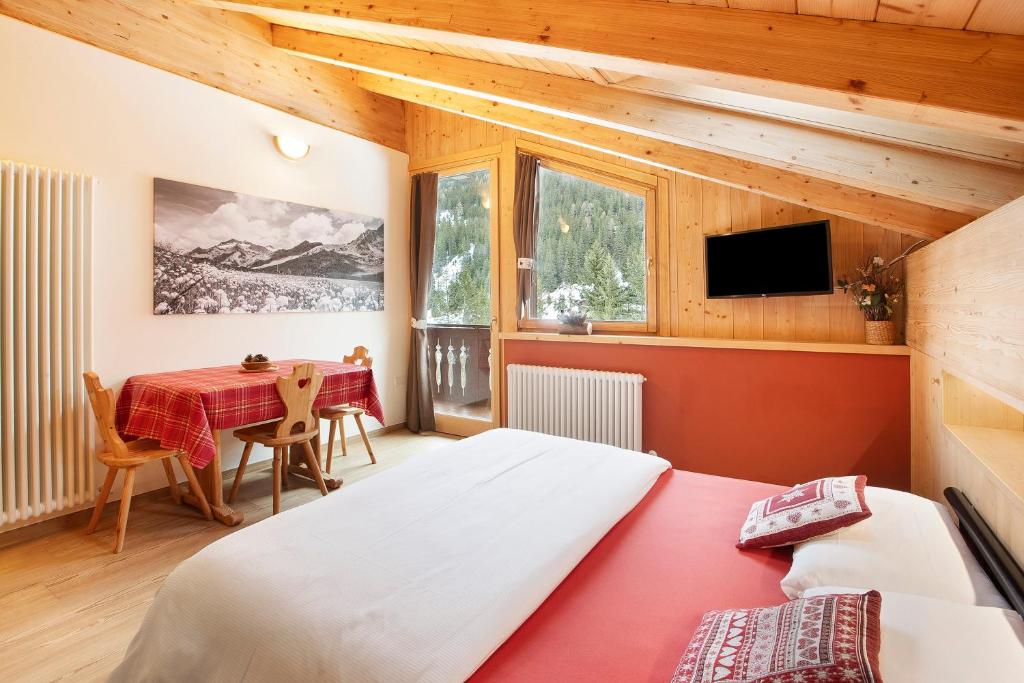 um quarto com 2 camas e uma mesa em Chalet Primula 14 em Santa Caterina Valfurva