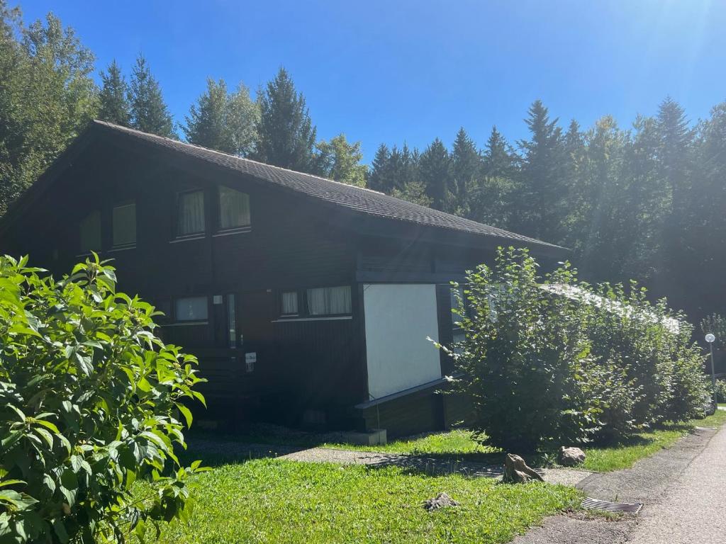 une maison noire avec une porte blanche dans une cour dans l'établissement Ferienwohnung Zirbelweg, à Siegsdorf