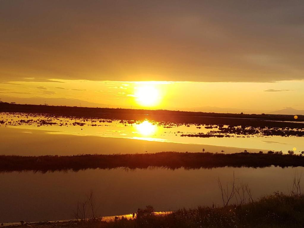 una puesta de sol sobre un cuerpo de agua con barcos en Dimitra's home, en Tesalónica