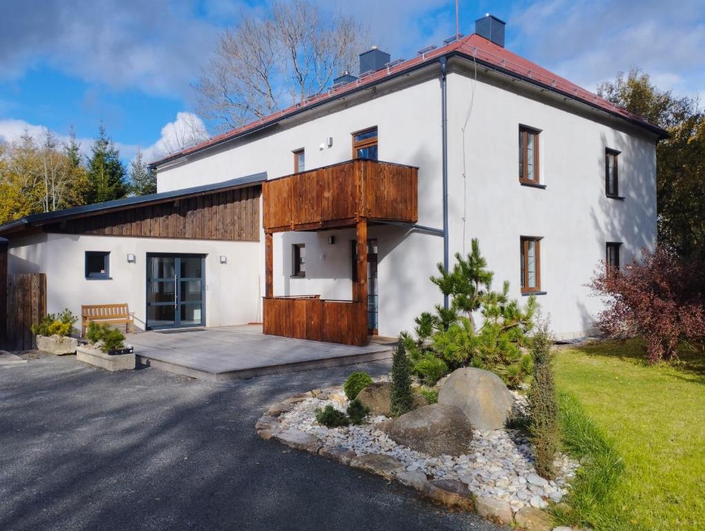 a large white building with a wooden door at Apartmány Lipno-Hory in Horní Planá