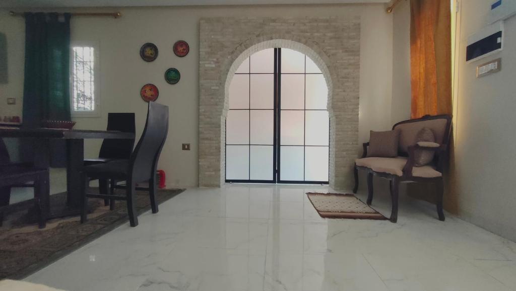 a living room with a piano and a table and chairs at Maison d'hôtes Dar Ranim Tozeur in Tozeur