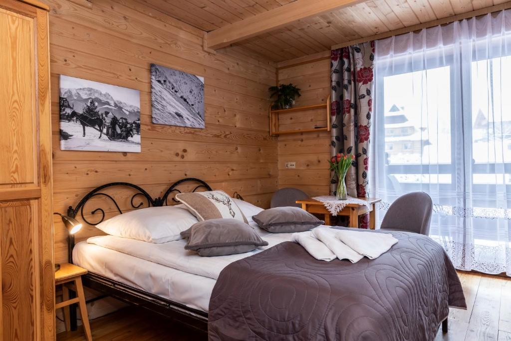 um quarto com uma cama num quarto com paredes de madeira em Willa u Jadzi em Zakopane