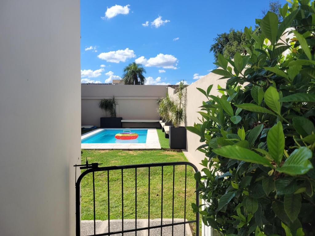 une cour avec une piscine et une clôture dans l'établissement Casa Roque Funes, ubicado en Cerro de las Rosas Córdoba, Ofrece, Asador, Pileta, Cercanias, Estadio Kempes, aeropuerto Ambrosio Taravella, Orfeo Superdomo, Córdoba Shopping Mall, Sanatorio Allende, INCLUYE IMPUESTOS Y CARGOS, à Córdoba