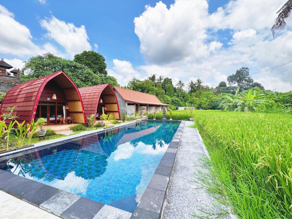 Bild eines Pools vor einem Haus in der Unterkunft Uma Raos Cottage in Ubud