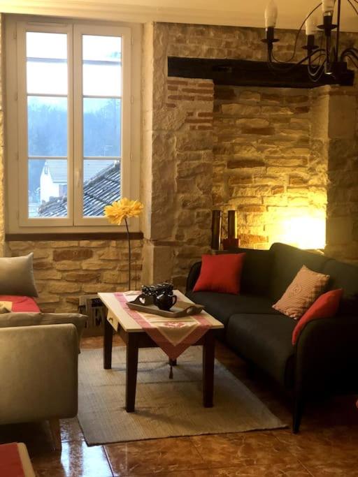 ein Wohnzimmer mit einem Sofa und einem Tisch in der Unterkunft La maison de Jeanne in Santenay