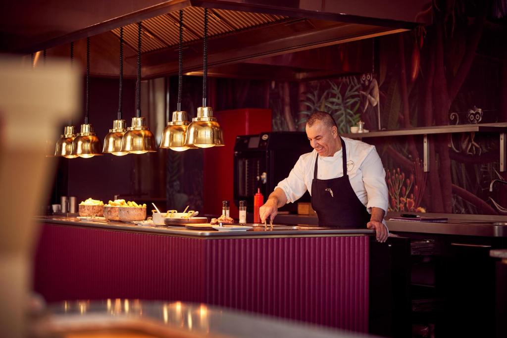 a man standing in a kitchen preparing food at Van der Valk Hotel Brussels Airport in Diegem