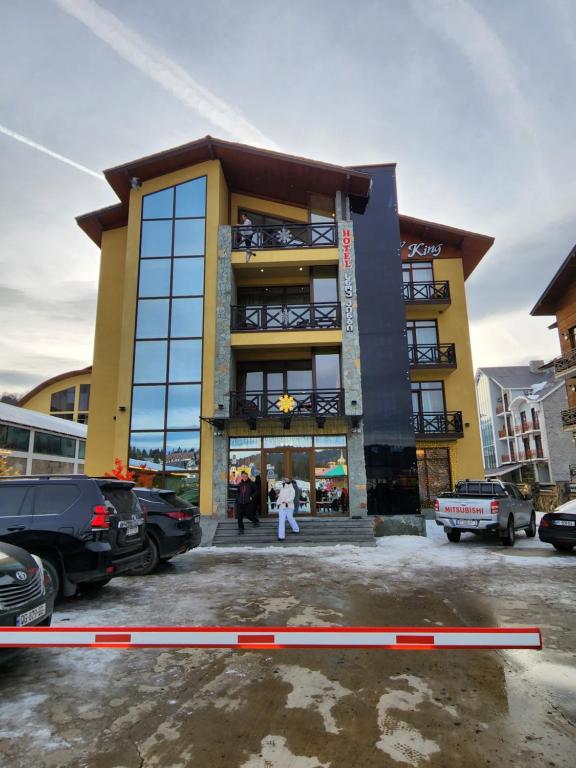 un edificio giallo con persone che lo circondano di Snow King Hotel a Bakuriani