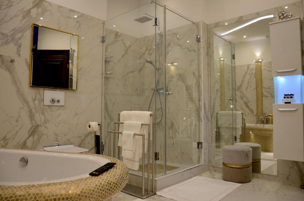 a bathroom with a tub and a glass shower at Gemütliche Apartment Lucky und Lucky de Luxe in Bremerhaven