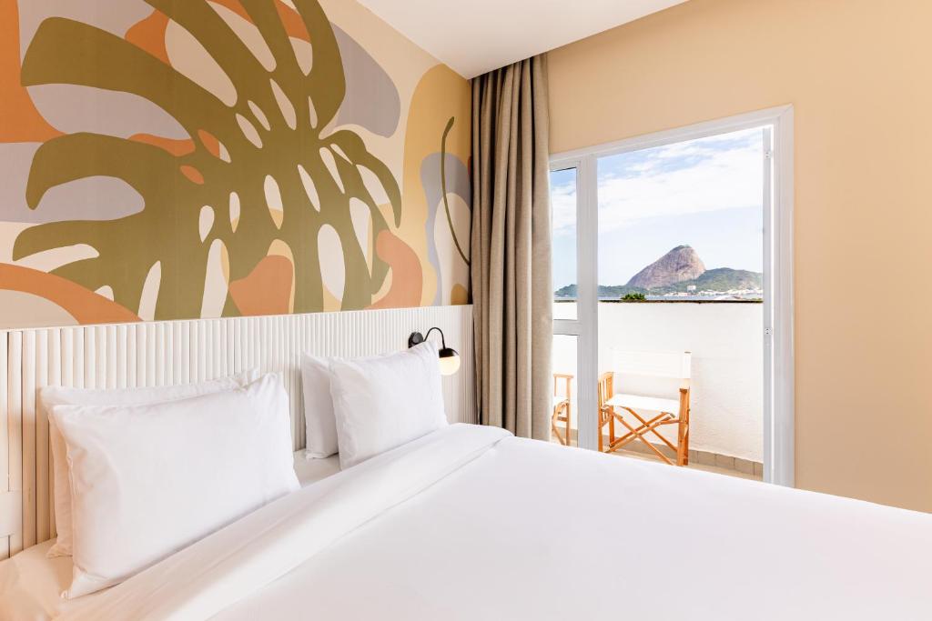 una camera con un grande letto e vista sull'oceano di B&B HOTEL Santos Dumont a Rio de Janeiro