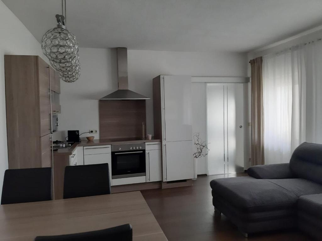 ein Wohnzimmer mit einem Sofa und einer Küche in der Unterkunft Ferienwohnung Leithaberg in Eisenstadt