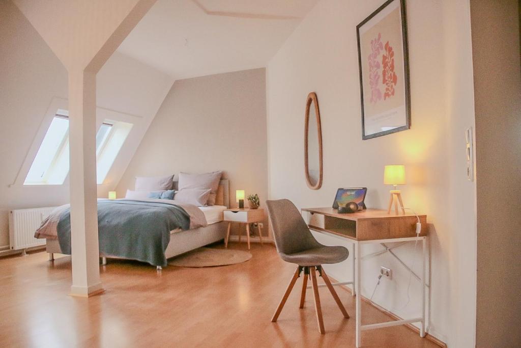 sypialnia z łóżkiem, biurkiem i krzesłem w obiekcie Hygge Homes - Traumhafte Altbauwohnung nahe Lüneburgs Altstadt w mieście Lüneburg