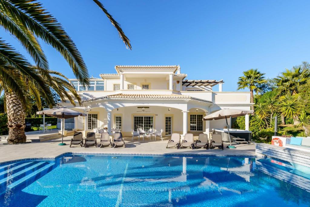 a villa with a swimming pool and a house at Alcore Luxury Golf Villa at Alto Golf Alvor in Alvor