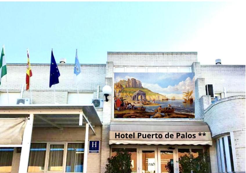 Hotel Puerto de Palos (La Rabida) في بالوس دي لا فرونتيرا: لوحة جدارية على جانب فندق بويرتو دو بالياس