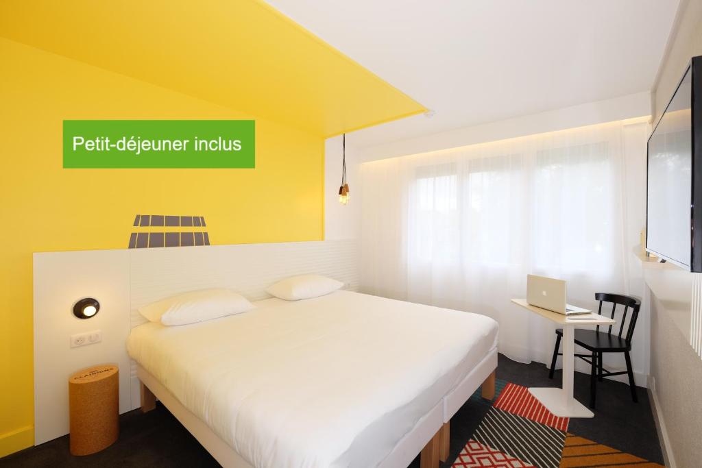 Llit o llits en una habitació de Hôtel ibis Styles Auxerre Nord