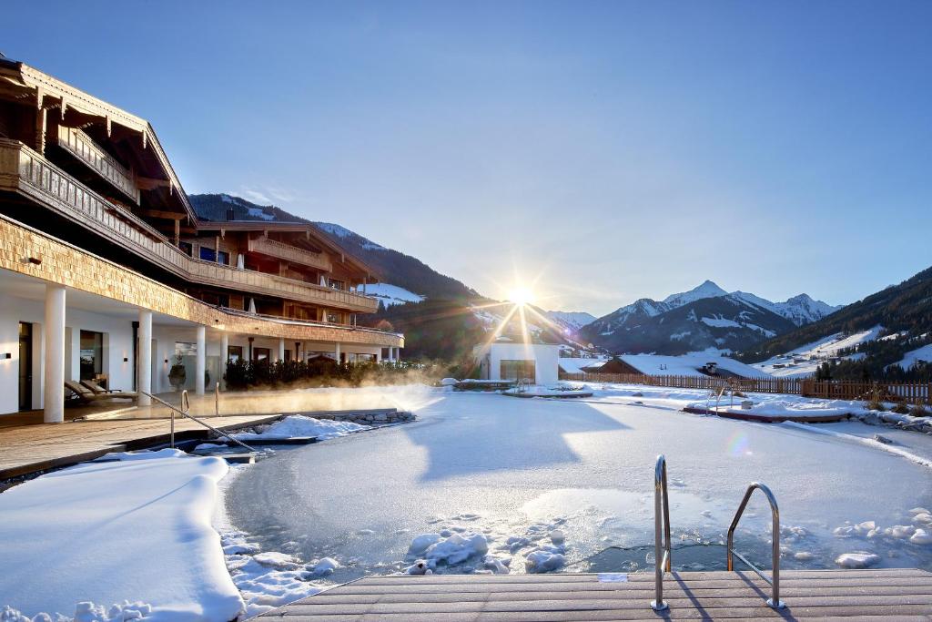 - Vistas a un lago congelado frente a un edificio en Der Böglerhof - pure nature spa resort, en Alpbach