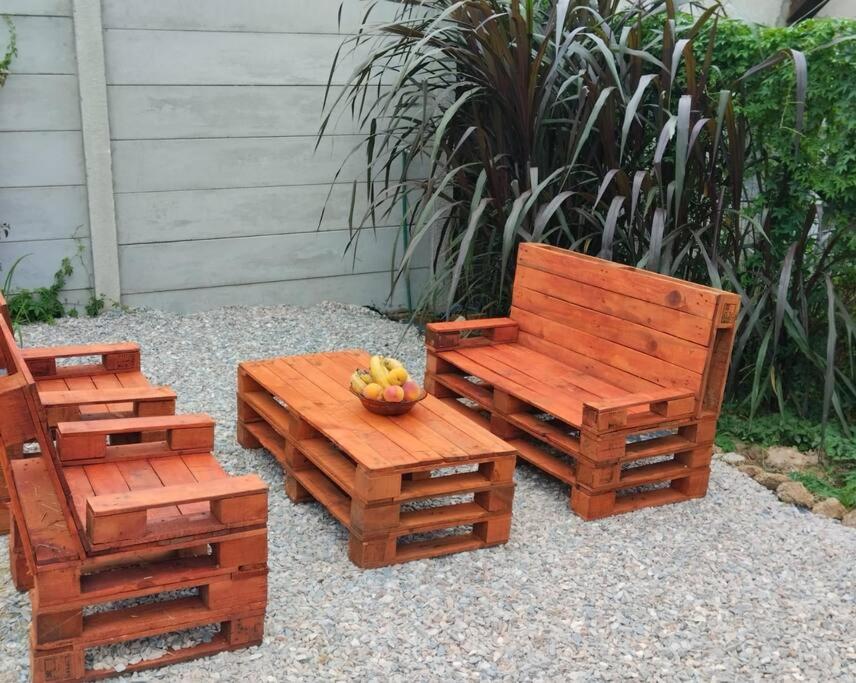 een houten bank en een fruitschaal op een tafel bij Casa contenedor super cómoda in La Floresta