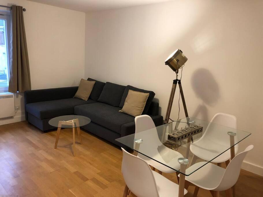 un soggiorno con divano, tavolo e sedie di Appartement 2/3 pièces (55m²) au cœur du Vexin a Chars