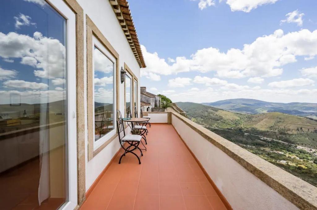 uma varanda com 2 cadeiras e uma mesa com vista em Casa da Arvore em Marvão