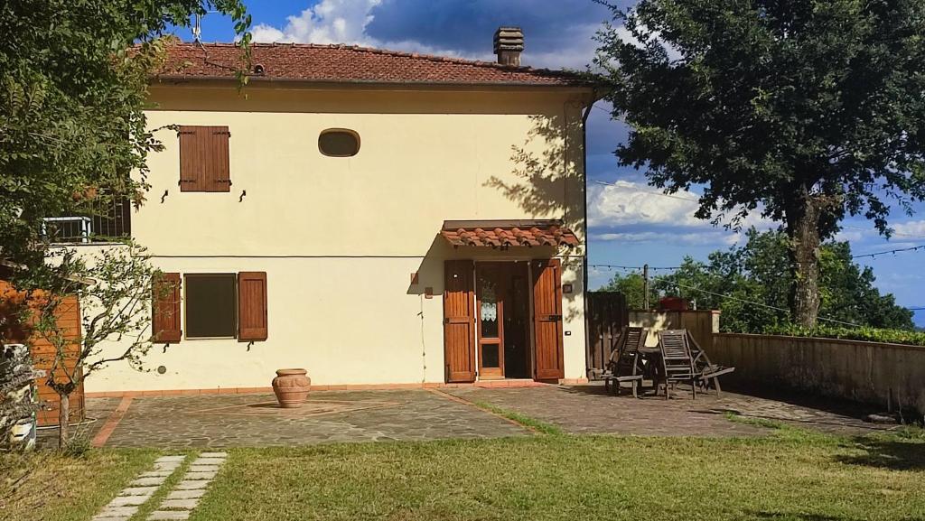 een groot wit huis met een patio ervoor bij Casa Baggino in Pistoia