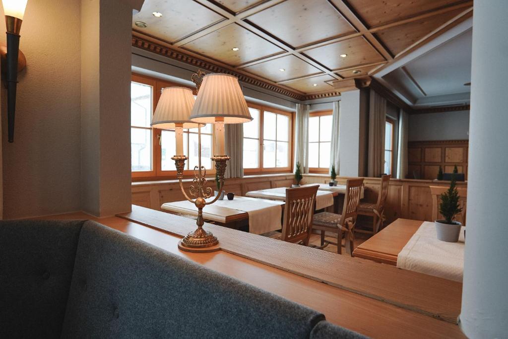 a dining room with a table and chairs and windows at Hotel Acerina Superior in Lech am Arlberg