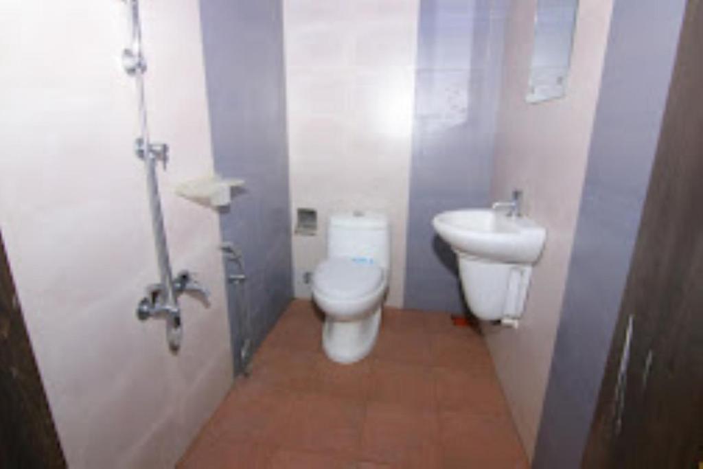 a bathroom with a toilet and a sink at Keloth Tharavad Kerala in Panamaram