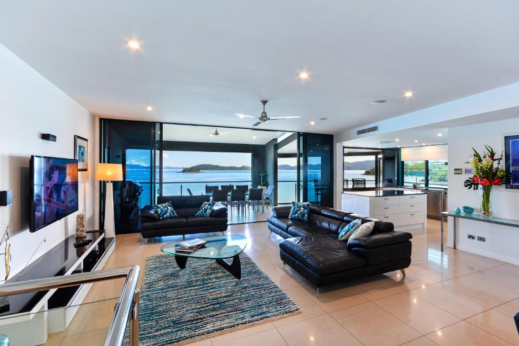 ein Wohnzimmer mit 2 Sofas und einem Tisch in der Unterkunft Edge 11 & Free Buggy - Hamilton Island in Hamilton Island