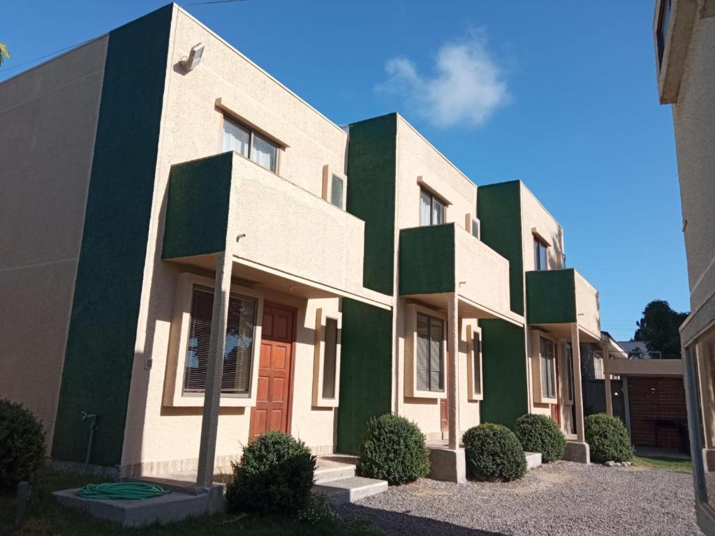 un edificio con zonas verdes y blancas en Cabanas Piedras Preciosas, en El Quisco