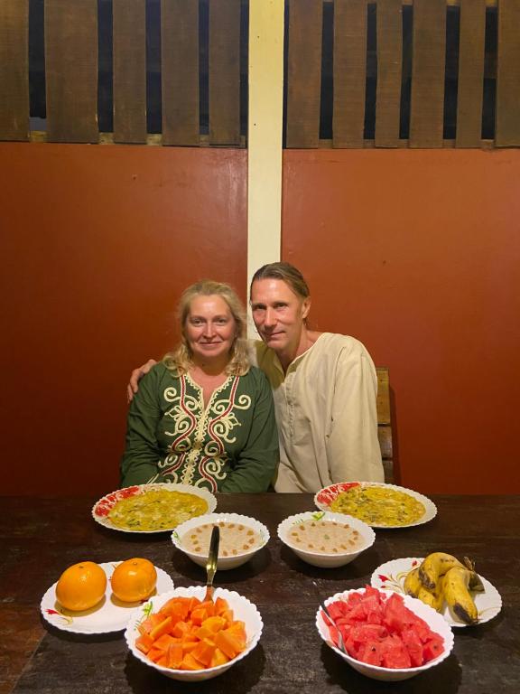 a man and a woman sitting at a table with plates of food at Dove cottage in Cherai Beach