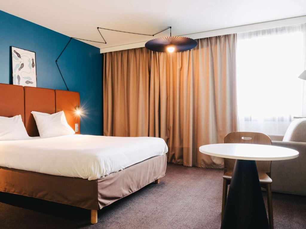 A bed or beds in a room at Ibis Rouen Centre Rive Gauche Mermoz