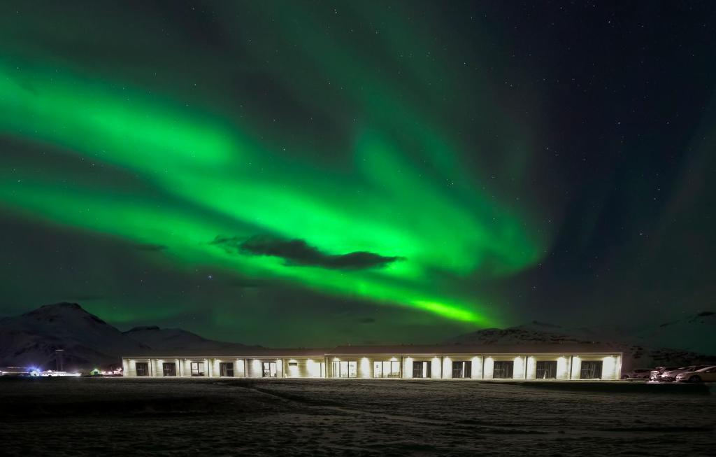 un immeuble de bureaux avec l'aurore boréale dans l'établissement Seljavellir Guesthouse, à Höfn