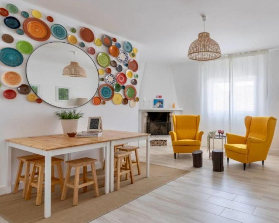 a living room with a table and chairs and a mirror at Galagana Charm House in Golegã