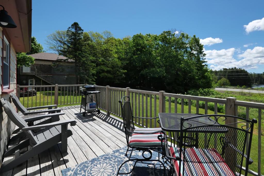 eine Terrasse mit einem Grill und einem Stuhl darauf in der Unterkunft Cozy Pond Side Cottage in Bar Harbor! [The Nook] in Bar Harbor