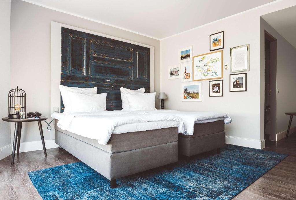 a bedroom with a large bed with a blue rug at Hotel Berlin, Berlin, a member of Radisson Individuals in Berlin