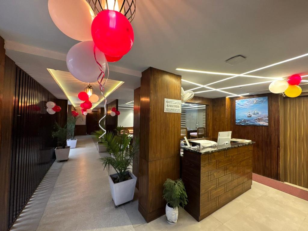 eine Lobby mit roten und weißen Ballons und einer Theke in der Unterkunft Hotel Northwind Mohali in Mohali