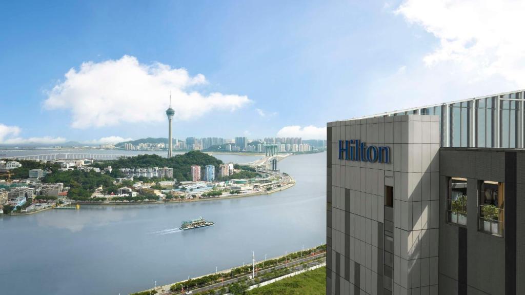 un edificio junto a un río con un barco dentro en Hilton Zhuhai, en Zhuhai