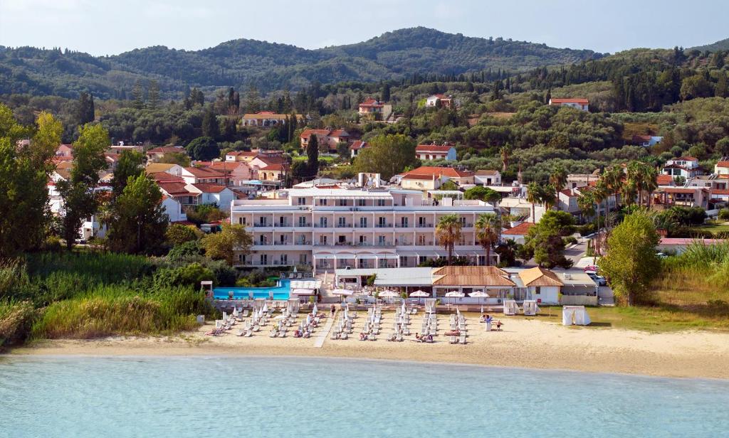 un hôtel sur une plage avec des chaises et des parasols dans l'établissement Cavomarina Beach- Adults Only, à Kavos