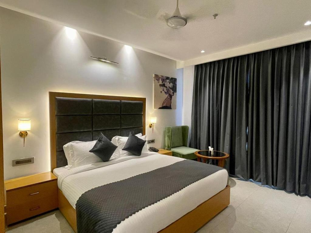 a bedroom with a large bed and a large window at HOTEL Tamarind in Mohali