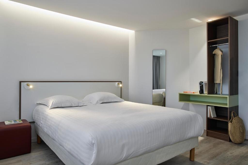 Tempat tidur dalam kamar di Hotel-Restaurant Isidore Nice Ouest