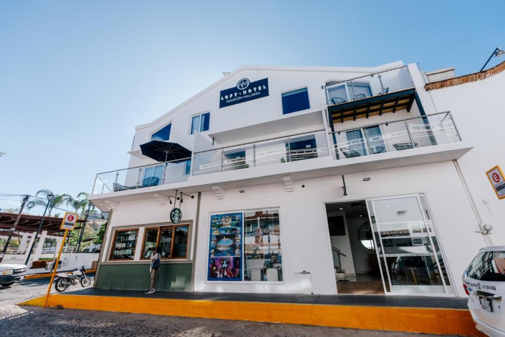 プエルト・バジャルタにあるLoft Hotel Malecón Vallartaの看板が貼られた白い建物