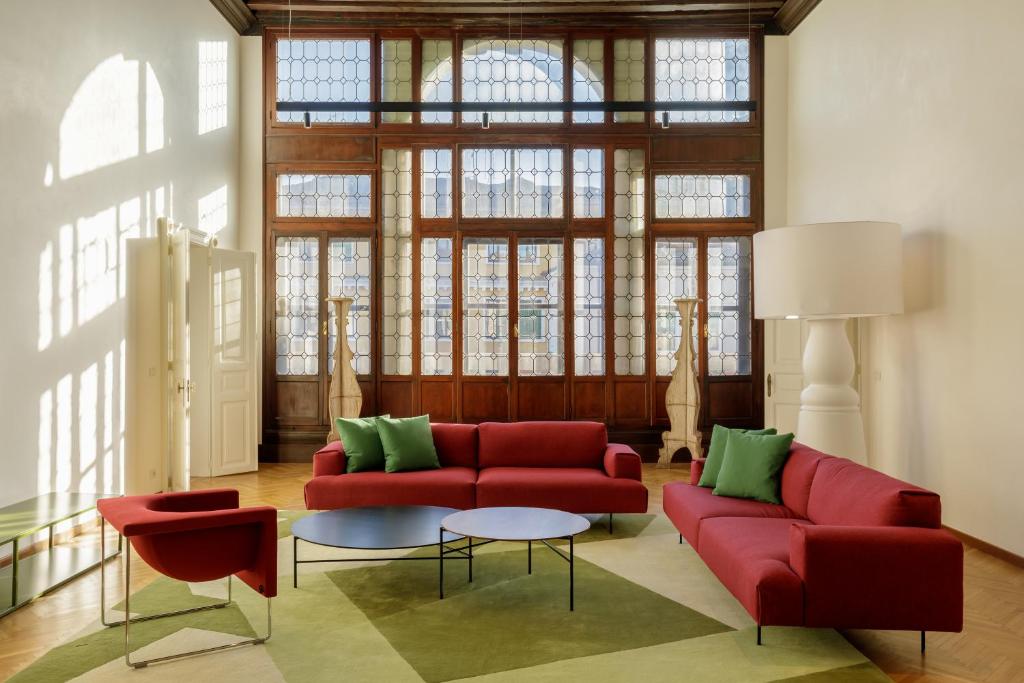 a living room with a red couch and a table at Palazzo Dei Fiori by Room Mate in Venice