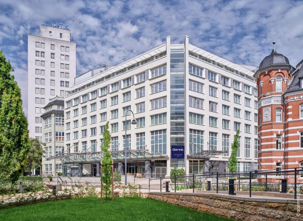 un grande edificio bianco con una torre dell'orologio davanti di Dorint Hotel Esplanade Jena a Jena