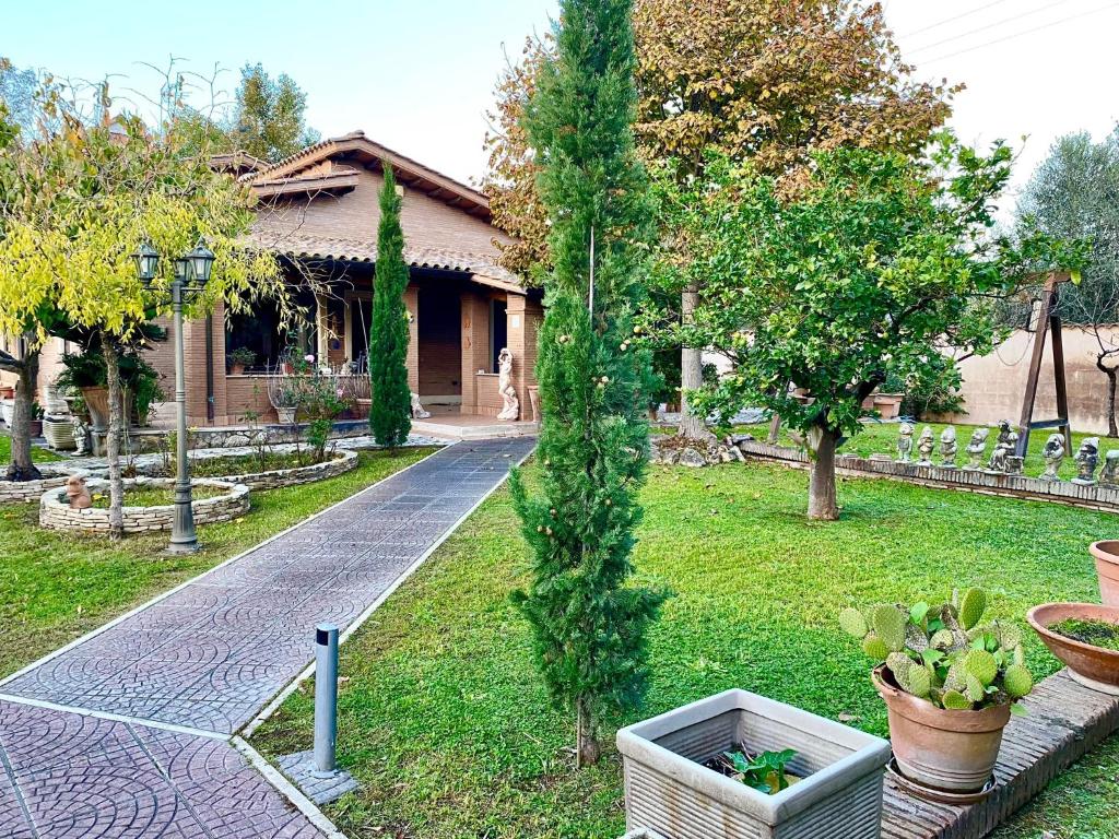 un giardino con un albero al centro di una casa di CLARABELLA a Ponte Galeria